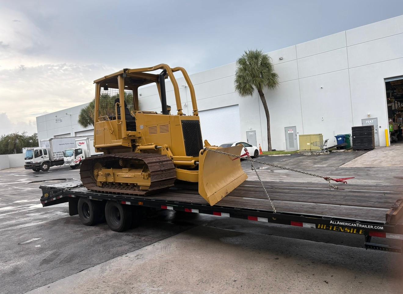 Track dozer chained down on a flatbed trailer for transport